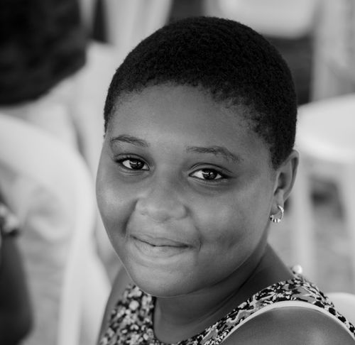 Free Black and white portrait of a smiling young girl with short hair, showcasing joy and innocence. Stock Photo