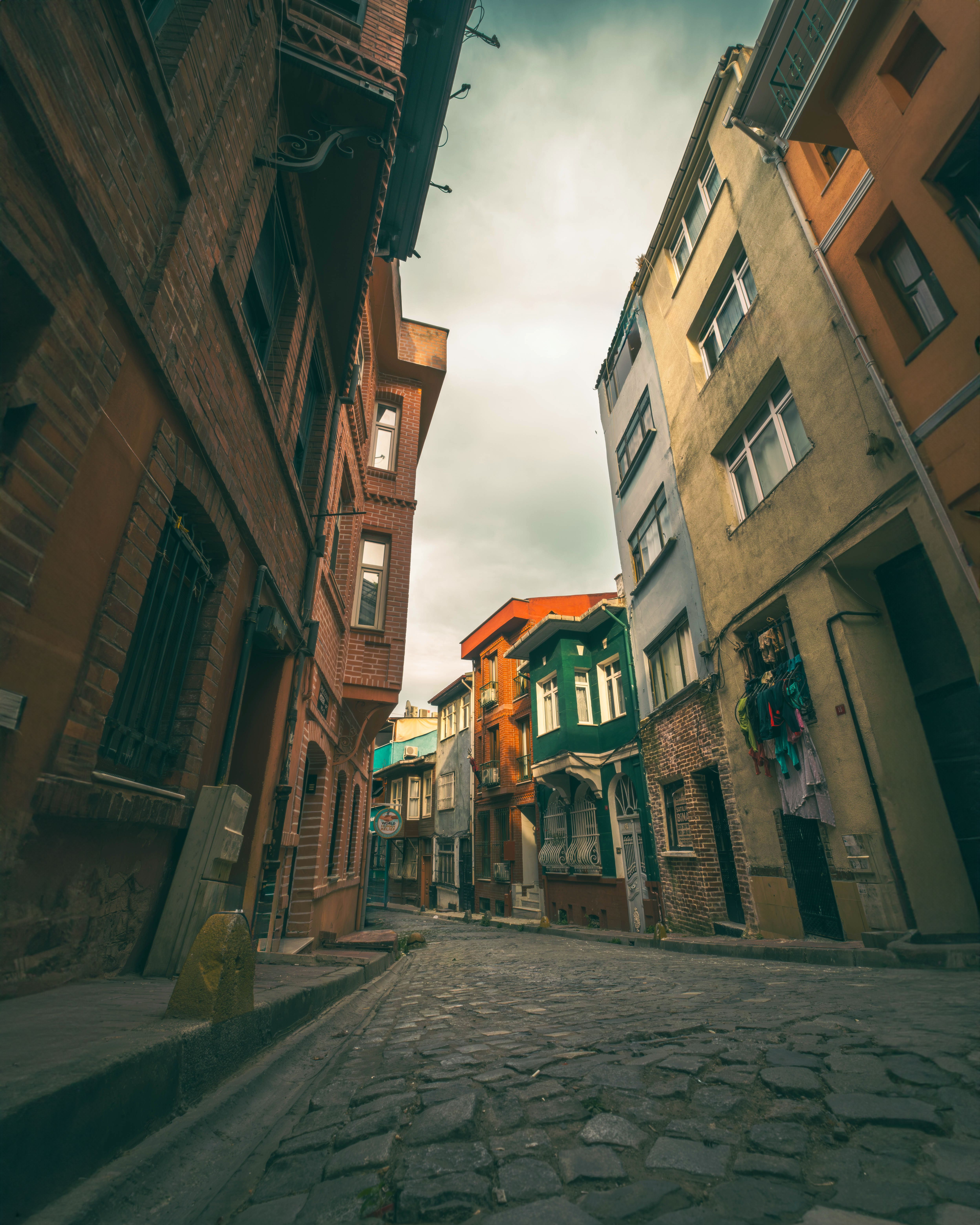 Explore a quaint cobblestone alley lined with colorful historical buildings in a serene town.