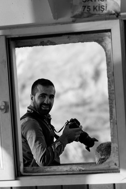Black and White Picture of a Man Holding a Camera 