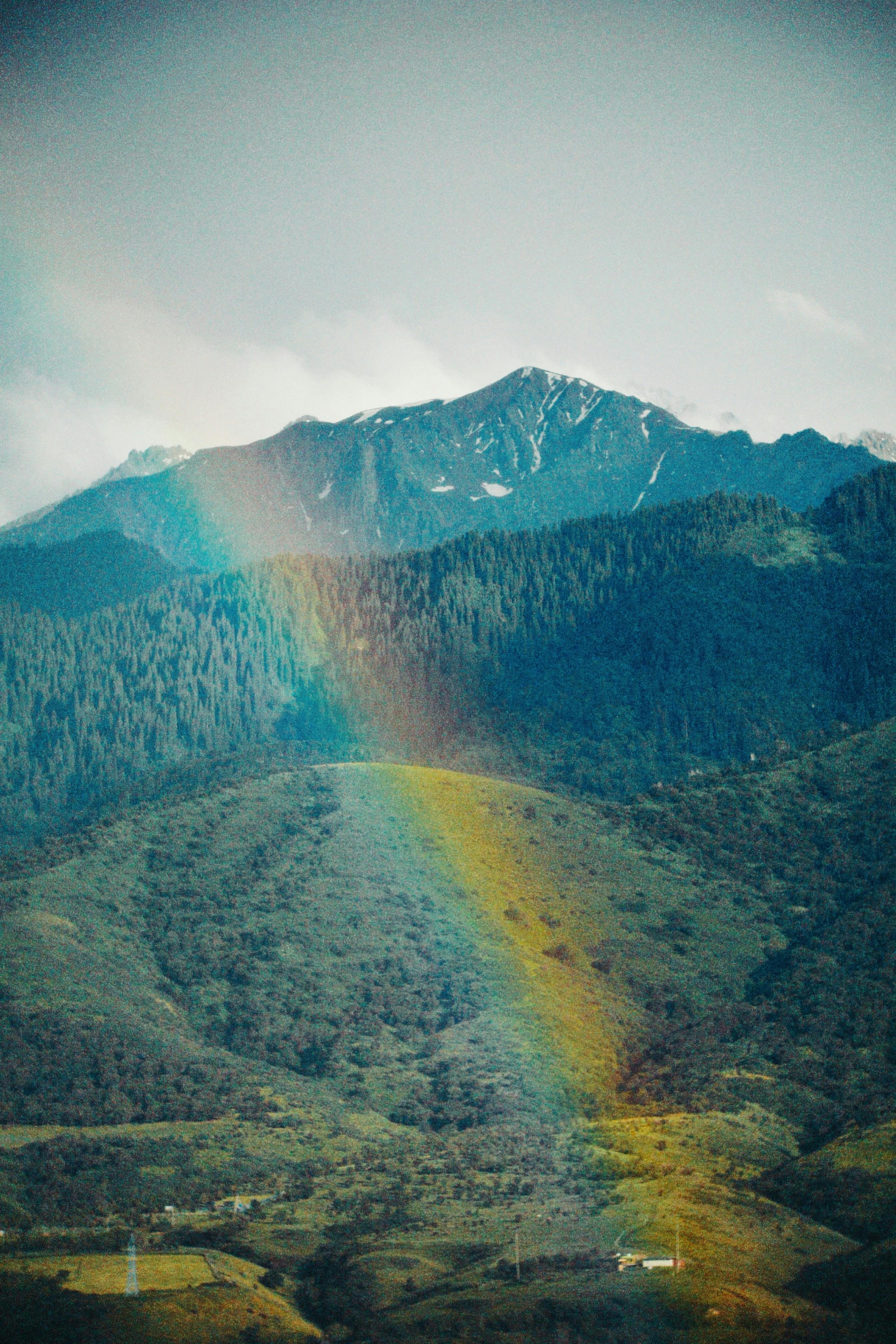 A beautiful rainbow arcs over the lush green landscape of Talgar, Kazakhstan.