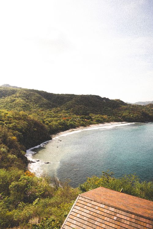 Free A serene tropical bay with lush greenery and clear waters, ideal for travel inspiration. Stock Photo