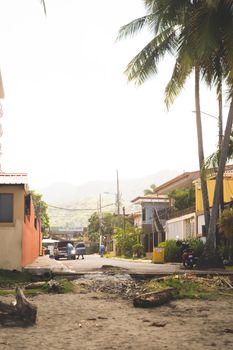 Peaceful street in Costa Rica with palm trees and mountain view, typical town vibe.