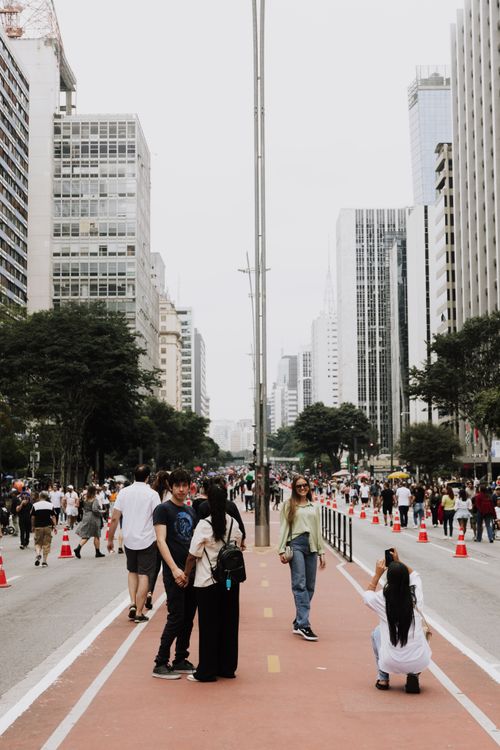 Free Crowds stroll along Paulista Avenue in São Paulo amidst modern skyscrapers and city life. Stock Photo