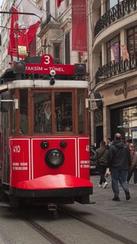 Classic red tram in Istanbul on İstiklal Avenue, capturing the hustle and bustle of city life.