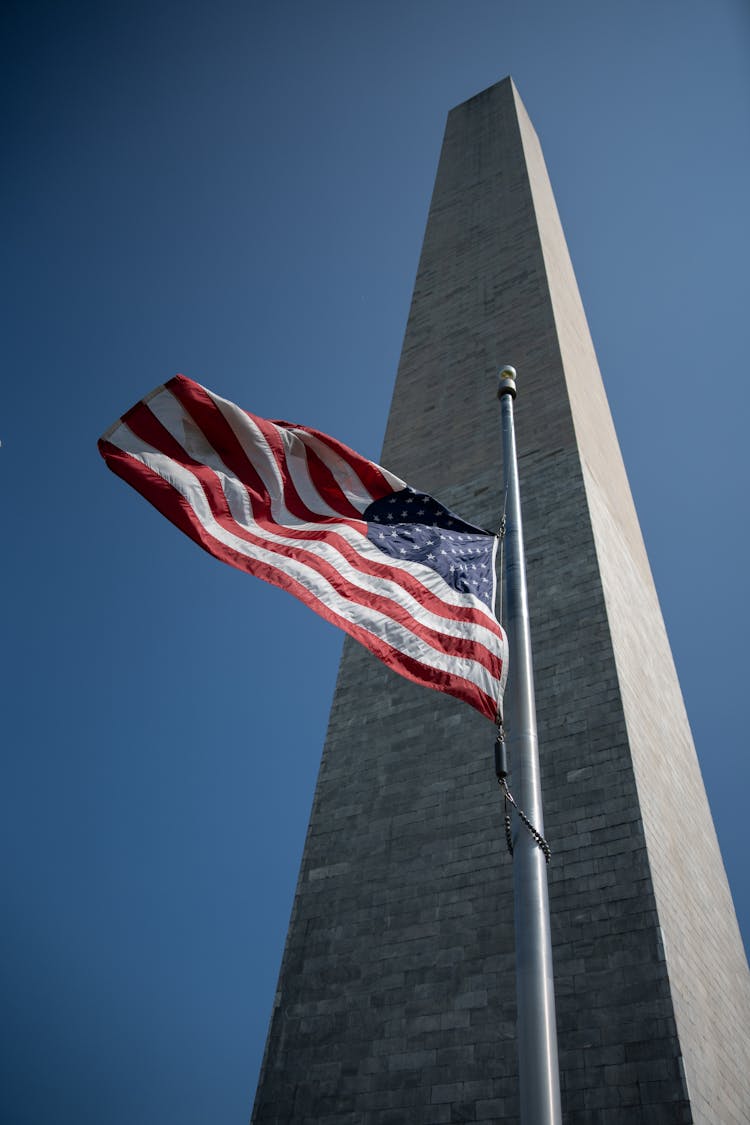 National Flag On Flagpole Near Monument