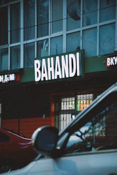Urban view of Bahandi restaurant facade in Talgar, Kazakhstan with vehicles in foreground.