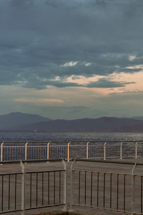 View of an Empty Pier and Mountains across the Bay 