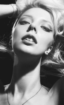 Elegant black and white portrait of a woman with bold eye makeup and flowing hair.
