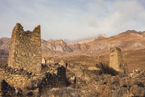 Free Explore ancient stone ruins set against a majestic mountain backdrop. Perfect for history and adventure enthusiasts. Stock Photo