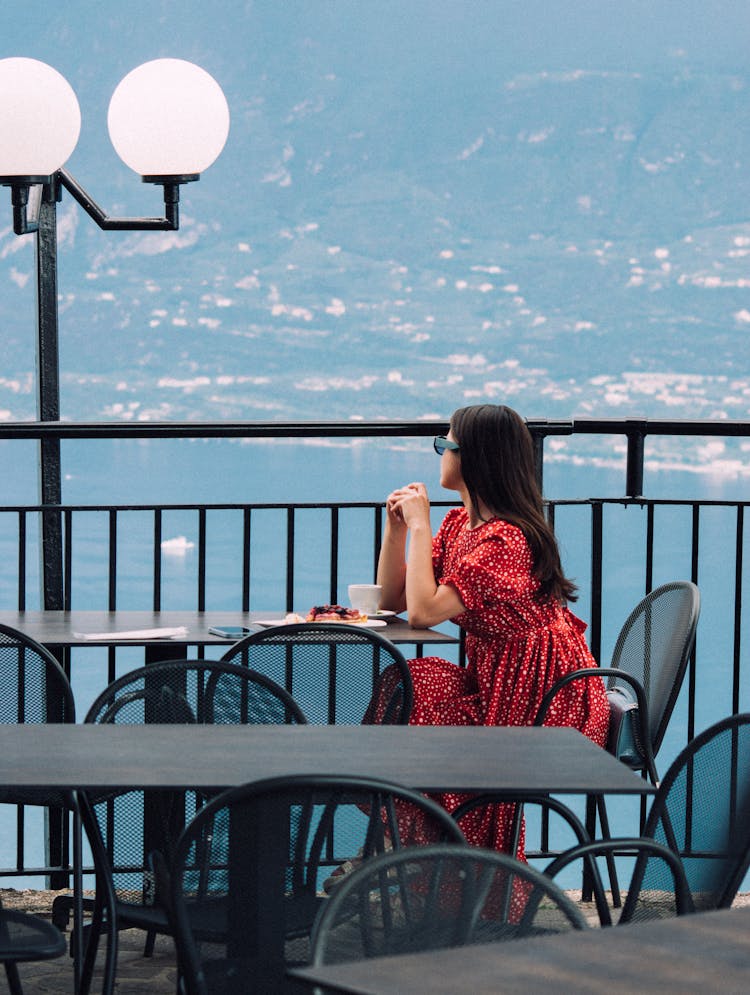 Woman Sitting In Cafe At Terrace Near Sea