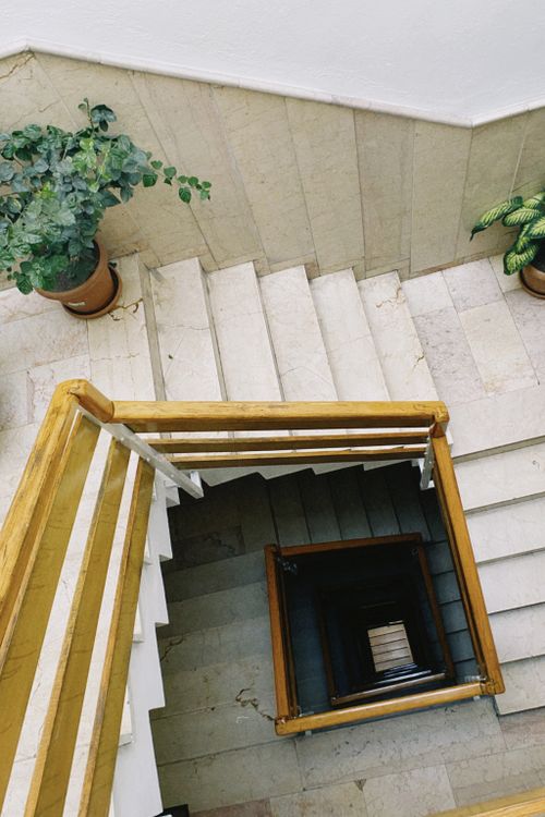 Free A vertical view of a spiral staircase with potted plants on each level. Stock Photo