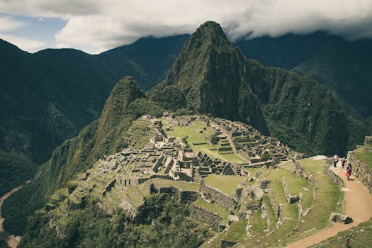 Stunning aerial shot of Machu Picchu with lush green surroundings and majestic mountains.