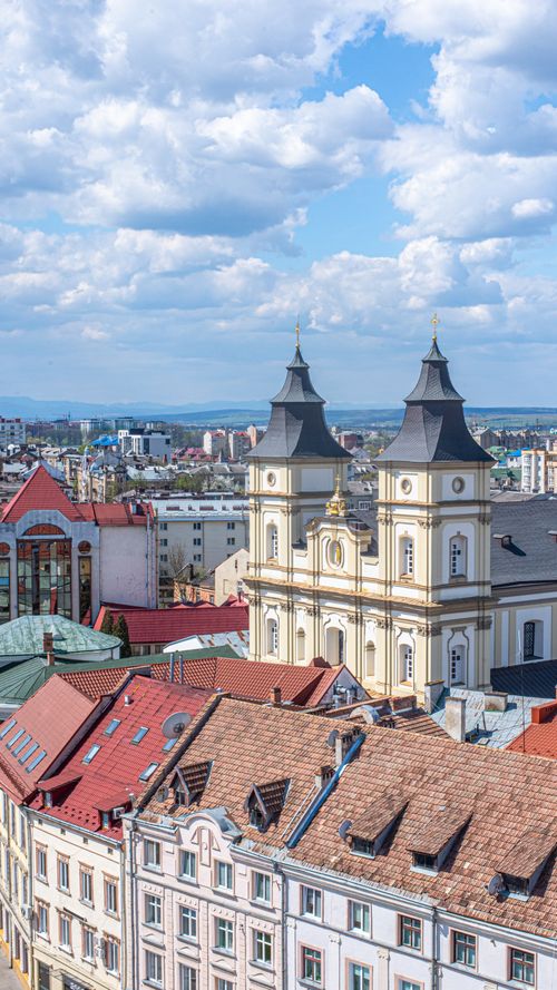 Free Aerial view of Ivano-Frankivsk showcasing historic churches and cityscape under a bright sky. Stock Photo