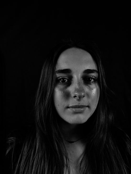 Free Dramatic black and white portrait of a woman with long hair on a dark background. Stock Photo