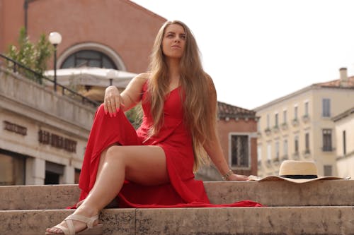 Woman in Red Dress Sitting on Stairs