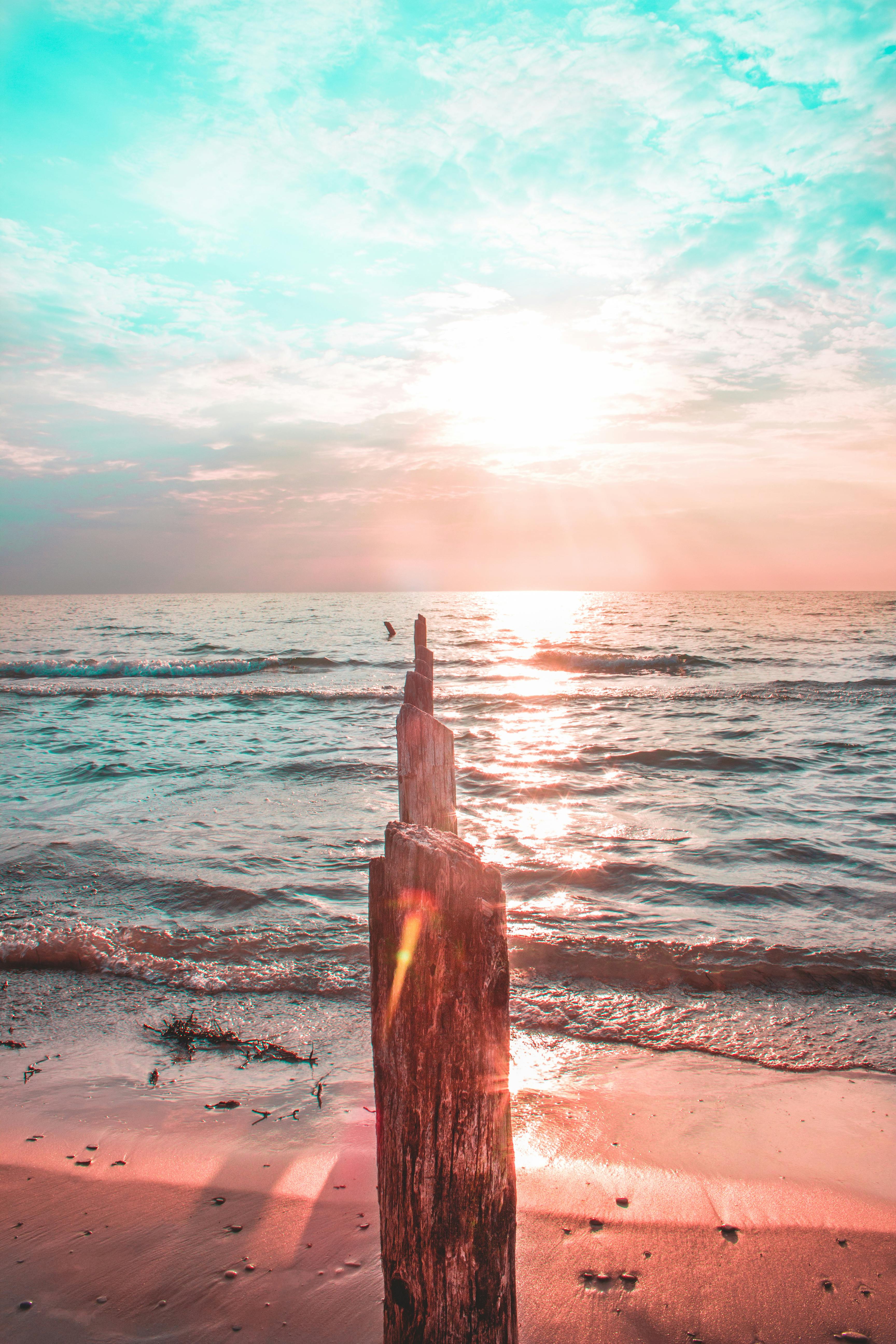 迷人的日出映照在宁静的海滩上，温暖的光线随着海浪轻轻反射
