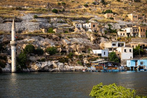 Free Explore the charming architecture of Halfeti's sunken city featuring a prominent minaret by the river. Stock Photo