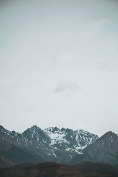 Snow-covered peaks under a cloudy sky in Almaty Province, Kazakhstan.