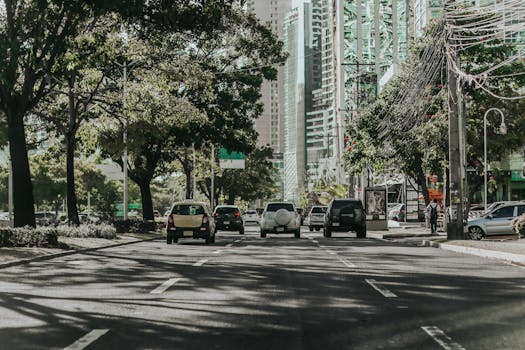 晴朗的天空下，高楼大厦和车辆矗立在繁华的城市街道两旁