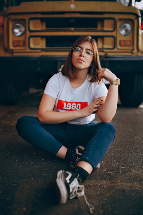 Mujer Vestida Con Camiseta Blanca Sentada En El Suelo Delante De Un Autobús Amarillo