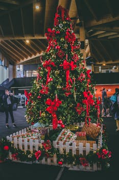 室内公共空间里，装饰精美的圣诞树与红色蝴蝶结和礼物相映成趣