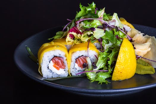 Delicious sushi rolls paired with a colorful salad, garnished with lemon and served on a dark plate.