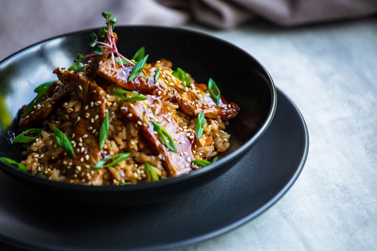 Beef teriyaki over white rice topped with sesame seeds and sliced green onions