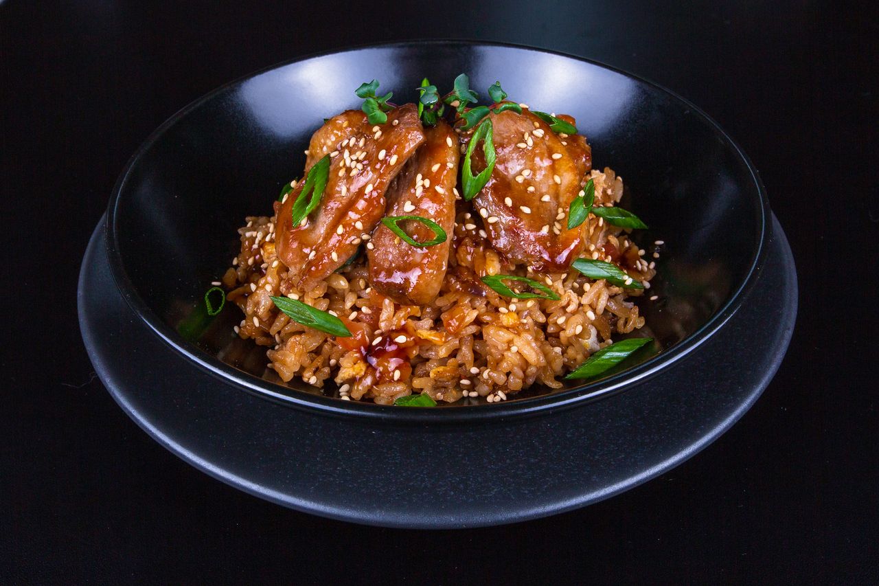 A hibachi chicken and rice dish topped with spring onion