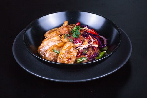 Free Savory chicken stir fry with vegetables served elegantly in a black bowl. Stock Photo