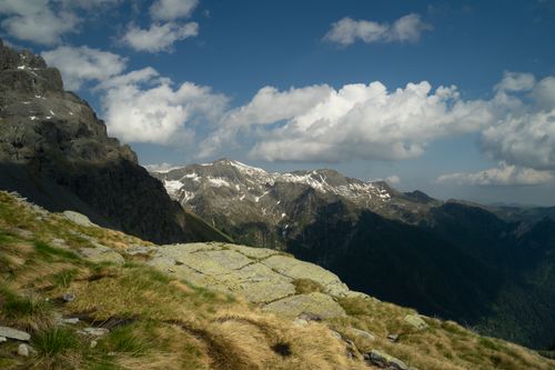Free Breathtaking view of a mountain range with snow-capped peaks and lush green valley. Stock Photo