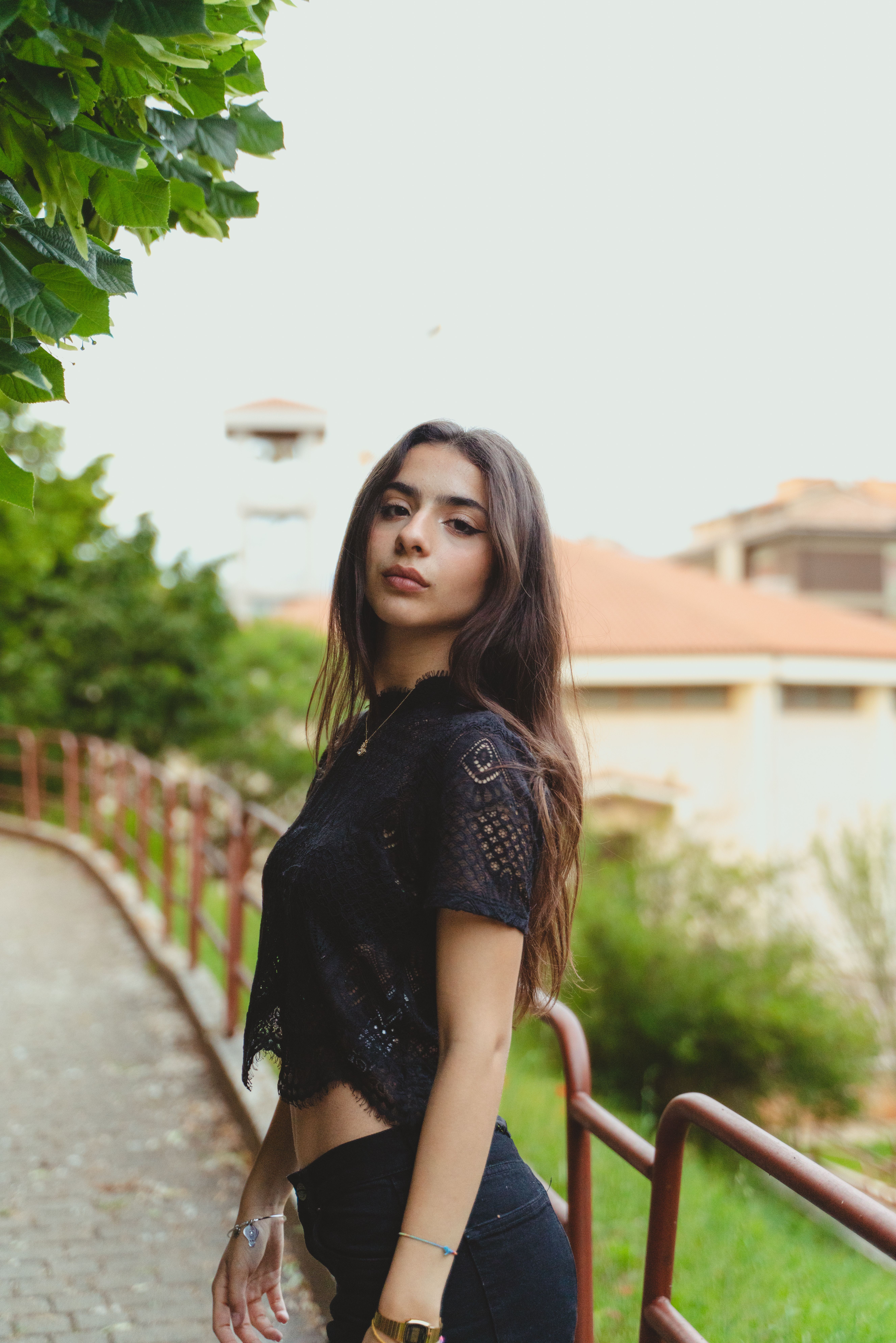 Young woman in a black outfit posing in a park in L'Aquila, Italy.