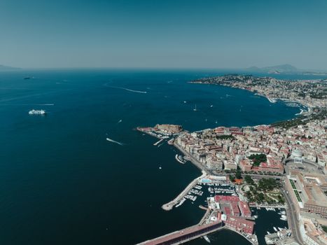 A stunning aerial view showcasing the vibrant city of Napoli, its bustling harbor, and the scenic Mediterranean coastline.