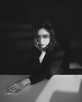 Artistic black and white portrait of a woman in dramatic lighting, evoking mystery.