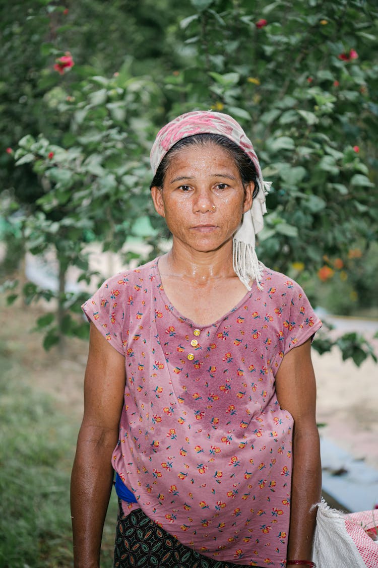 Old Woman In Headwear Posing In Garden