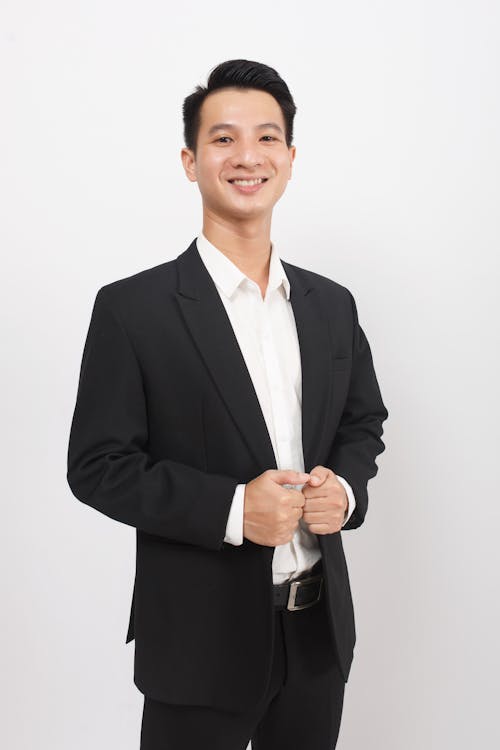 Smiling Young Man in Suit Posing on White Studio Background