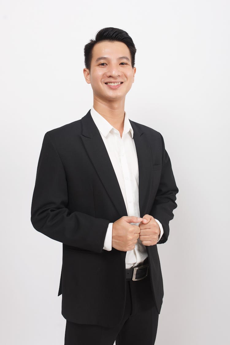 Smiling Young Man In Suit Posing On White Studio Background