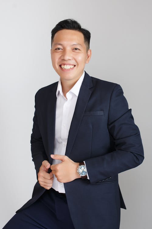 Smiling Man in Formal Wear Posing on White Studio Background