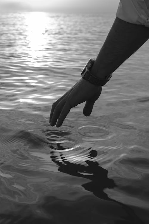 Free Man Approaching Hand to Water Stock Photo