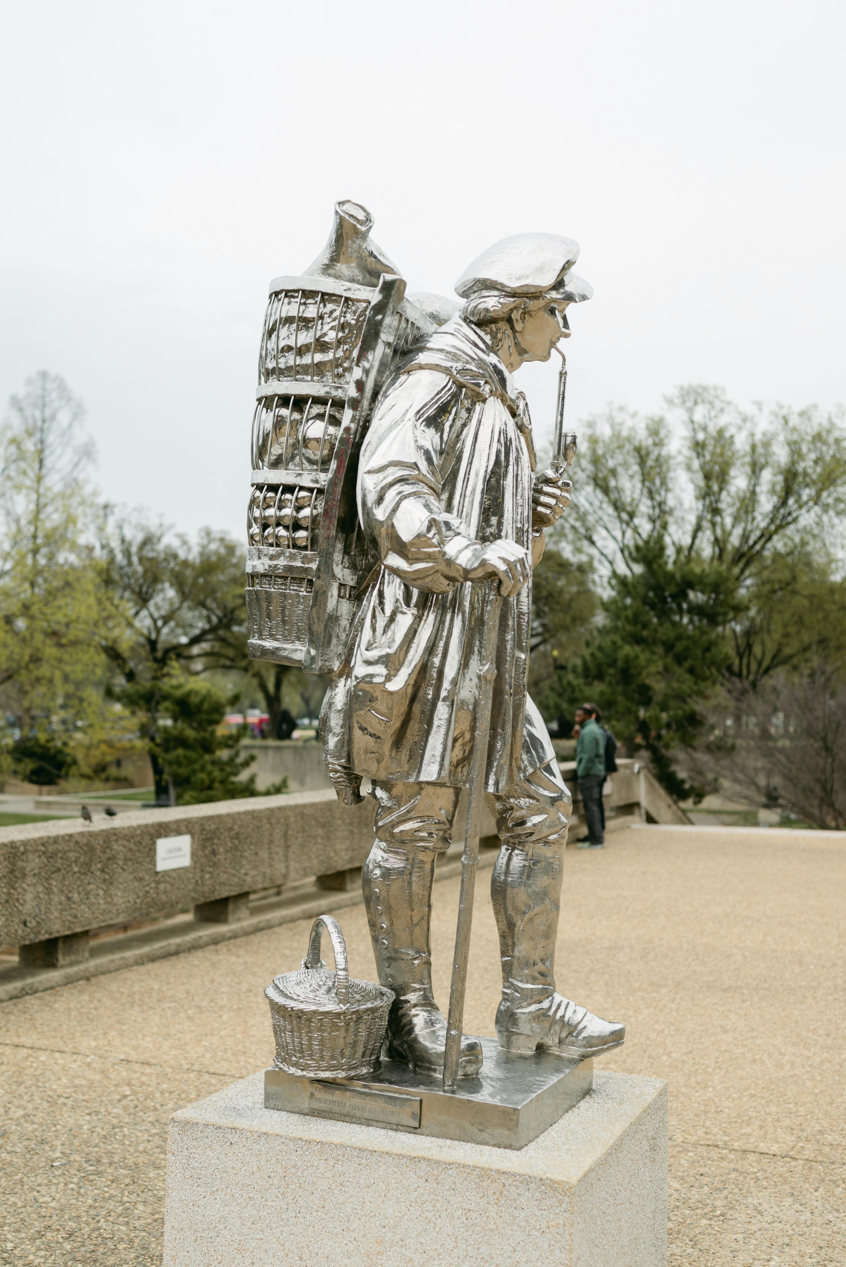 silver statue of a man smoking a pipe