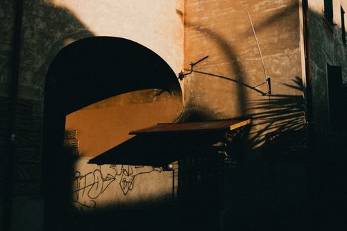 Free Dark shadows cast on an urban building wall during sunset, creating a moody ambiance. Stock Photo