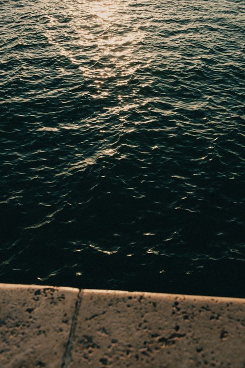Free Tranquil sunset reflecting on the sea creating a peaceful atmosphere. Stock Photo