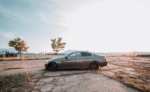 A car parked on a dirt road in the middle of a field