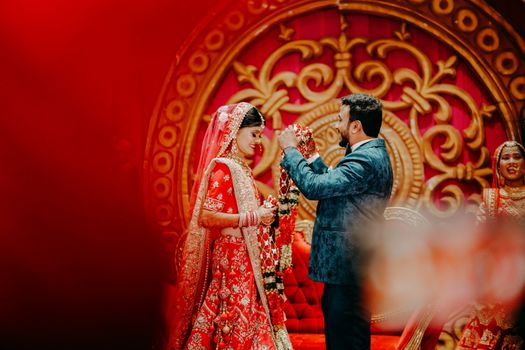 A joyful Indian couple exchange garlands in a traditional wedding ceremony in Durg, India.