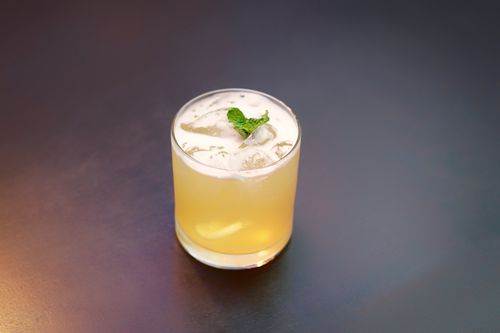 Free Glass of cocktail with ice and mint garnish on a black background, perfect for summer refreshment. Stock Photo