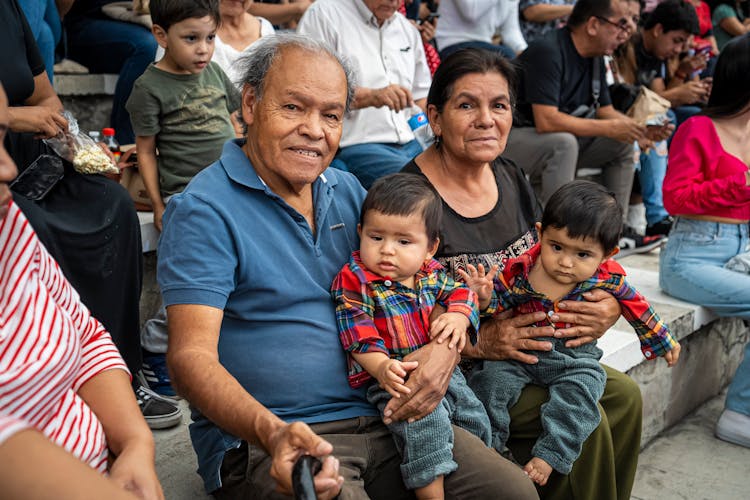 Grandparents Sitting With Grandchildren On Stands