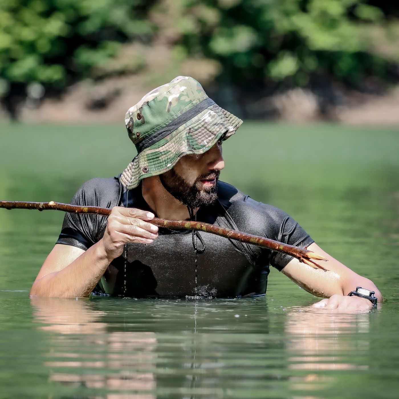 Man outdoors wearing a camouflage boonie hat with a chin cord