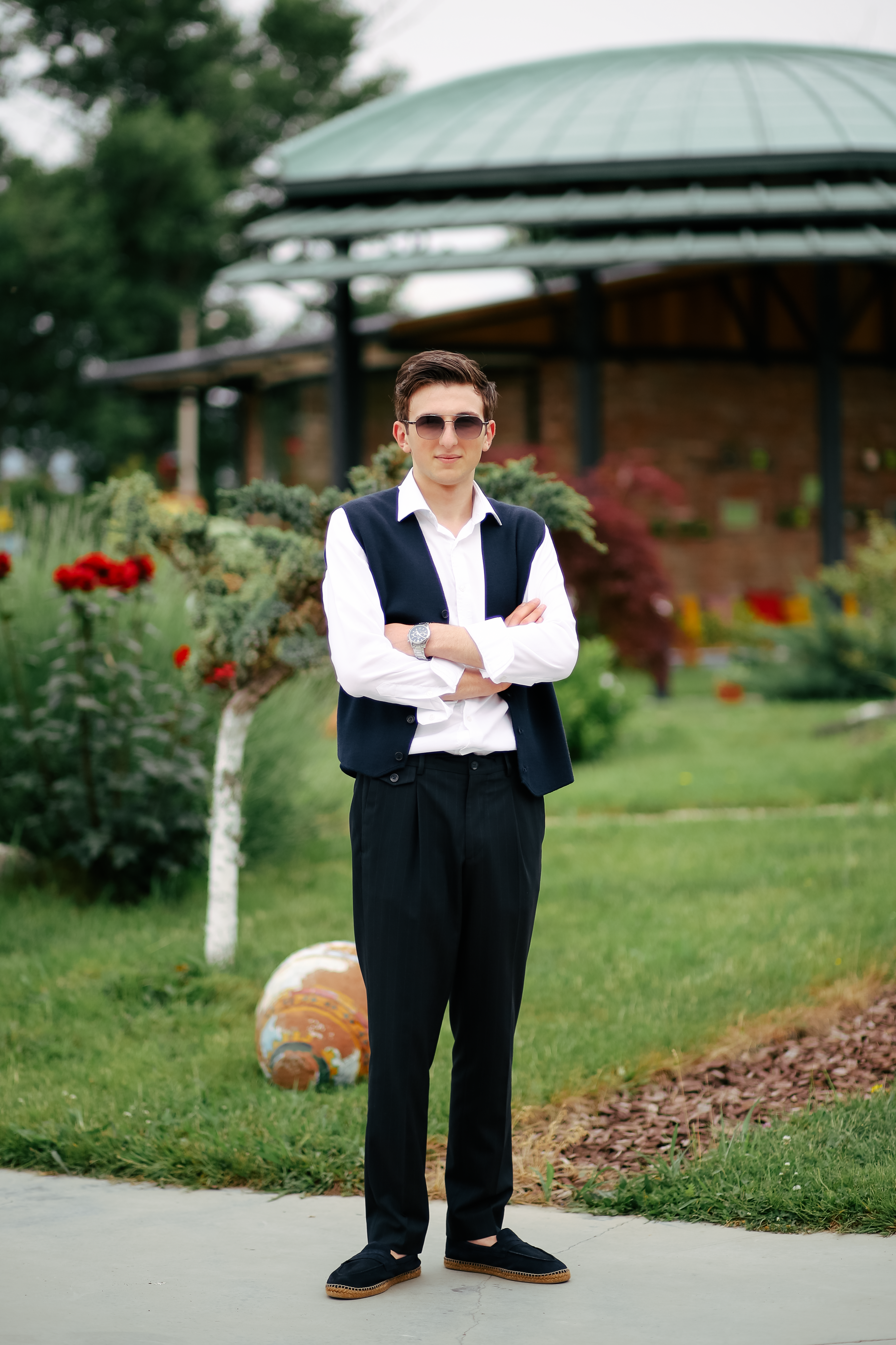 Man in sunglasses standing in a lush garden — photo by Photography Maghradze PH on Pexels