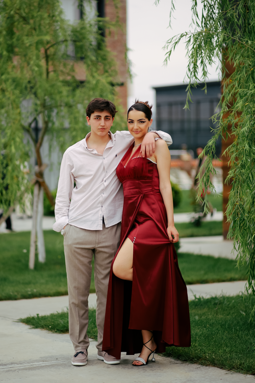 Free A well-dressed young couple poses together outdoors, exuding elegance in a park setting. Stock Photo