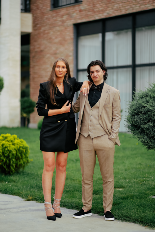 Free A well-dressed couple poses elegantly outdoors, showcasing fashion and elegance. Stock Photo