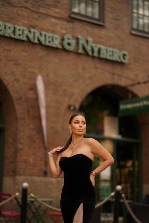 Young Woman in an Elegant Black Dress Posing in City 